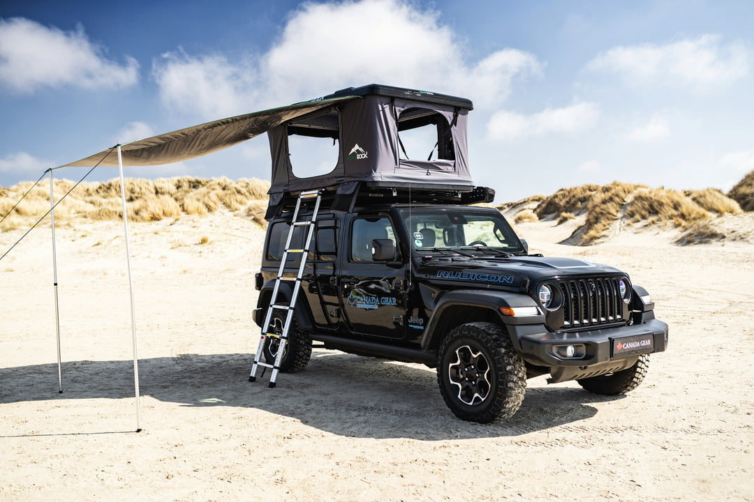 Jeep mit aufgebautem Gear Rock Dachzelt und Markise am Sandstrand – perfektes Setup für Offroad-Camping.
